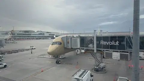 載我們來的金色 A350，停在空橋旁。