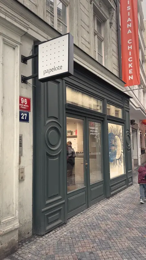 墨綠色的店門，櫥窗裡畫著一顆黑色太陽。